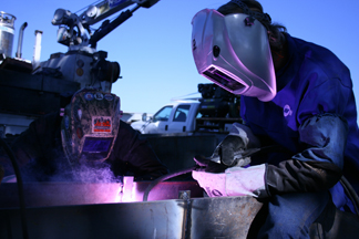 Image of two welders, showing  self-shielded flux-cored arc welding (FCAW-S) g application, welding