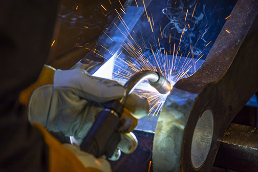 Image of a person welding with a semi-automatic MIG gun