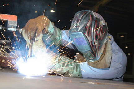 Image of a welder in a shop MIG welding