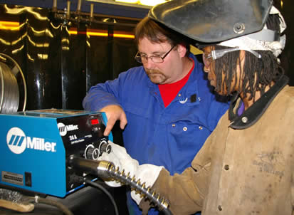 Image of an instructor teaching a student about setting the correct welding parameters.