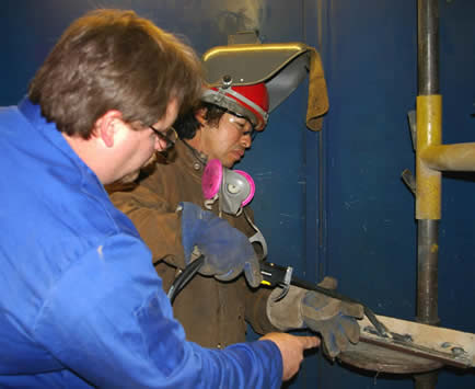 Image of an instructor helping a student about proper gun angles and positioning with Bernard's Dura-Flux gun.