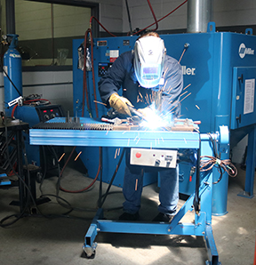 Image that shows person welding in a proper ergonomic setting on the plant floor