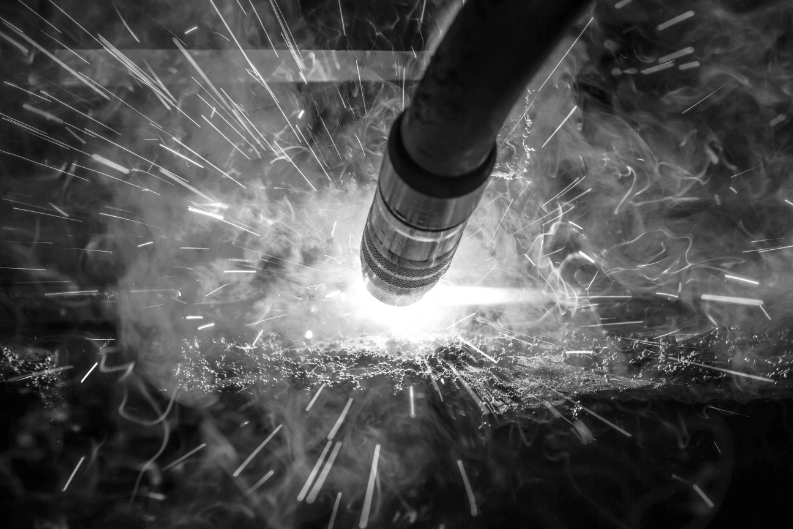 Black and white image of MIG Gun welding with sparks